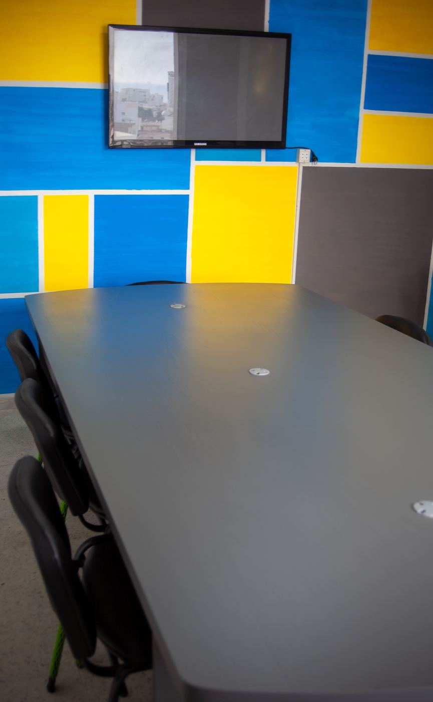 Salle de réunion d'INCUB SPACE aux murs jaunes et bleus