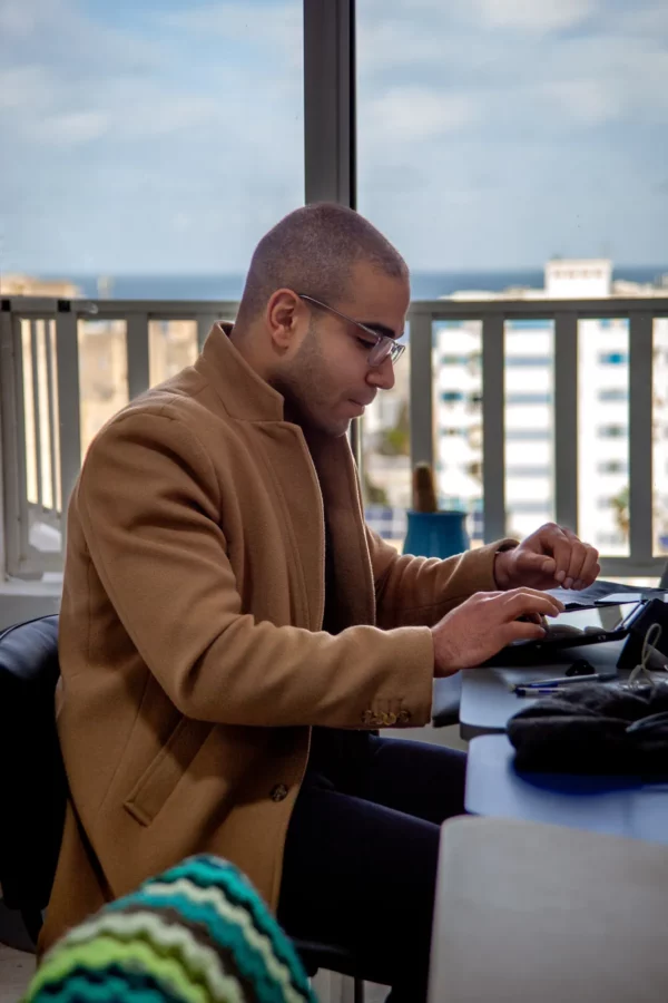 Entrepreneur au travail dans l'espace de coworking, vue sur la mer de Sousse
